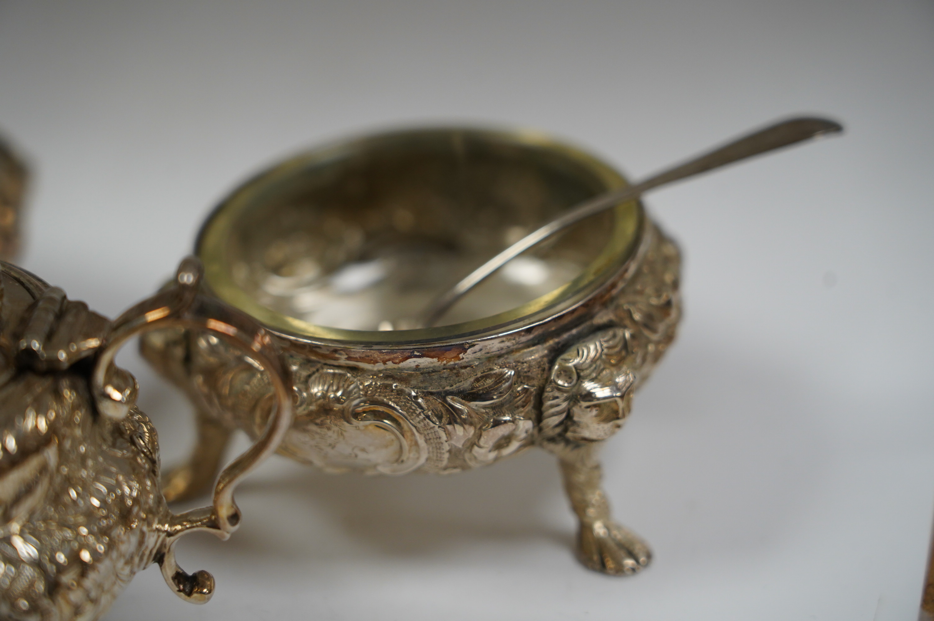 A Georgian Scottish silver mustard pot, width 9cm, marks rubbed, and a pair of similar Irish? silver cauldron salts and two associated later spoons. Condition - poor to fair